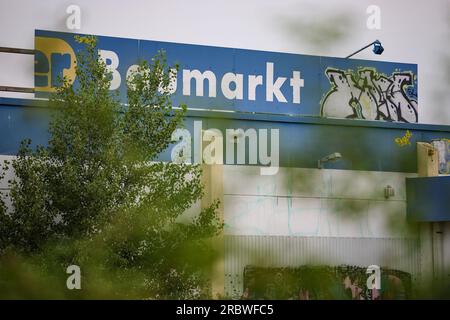 Leipzig, Deutschland. 10. Juli 2023. „Baumarkt“ verkündet immer noch ein Schild auf einem Praktiker-Laden, der seit Jahren geschlossen ist. Mit dem markanten Slogan „20 Prozent Rabatt auf alles außer Haustierfutter“ ging die Praktiker-Heimwerkerkette 2013 bankrott. Überschuldet und zahlungsunfähig infolge jahrelanger Diskontierung beantragte das Unternehmen am 11. Juli 2013 in Hamburg ein Insolvenzverfahren. Nach Angaben des Unternehmens beschäftigte Praktiker rund 20.000 Mitarbeiter und Betrieb über 300 Heimwerkerläden in Deutschland. Kredit: Jan Woitas/dpa/Alamy Live News Stockfoto