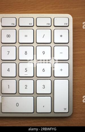 Ziffernblock einer Apple-Tastatur auf einem Holzschreibtisch. Stockfoto