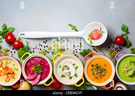 Auswahl an bunten Gemüsesuppen und Zutaten für Suppe. Draufsicht. Konzept der gesunden Ernährung oder vegetarischer Nahrung. Stockfoto