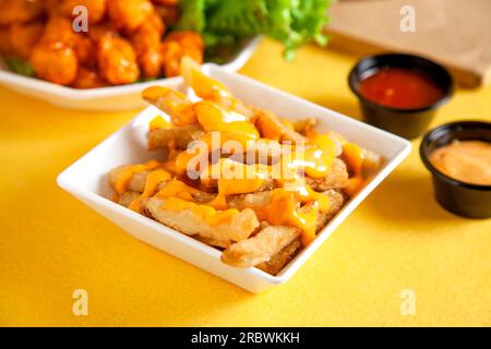 Pommes-Pommes-pommes, Kartoffelchips, garniert mit Dynamit-Soße der Insel, serviert auf einem Teller. Stockfoto