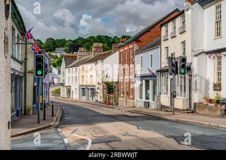 Eine sonnige Landschaft der Hauptstraße, die durch die kleine Stadt Lostwithiel, Cornwall führt. Viele verschiedene Architekturen säumen diese farbenfrohe Straße. Stockfoto