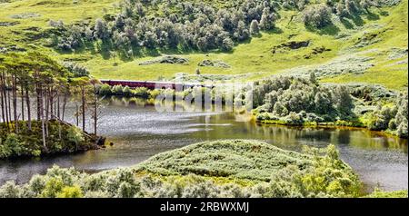 Jacobite Steam Train auf der Strecke entlang Loch Eilt und der Insel mit Dumbledores Grab in der Nähe der Westküste von Lochailort, Schottland Stockfoto