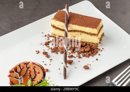 Tiramisu serviert mit Schokolade auf einem weißen Porzellanteller Stockfoto