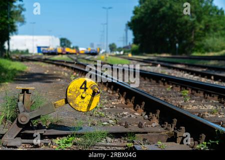 Nahaufnahme der Pfeile-Bahnschienen. Bahnhof im Hintergrund unscharf. Stockfoto