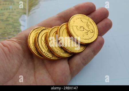 Eine Hand hält eine Goldmünze mit dem Wort Drache drauf. Stockfoto