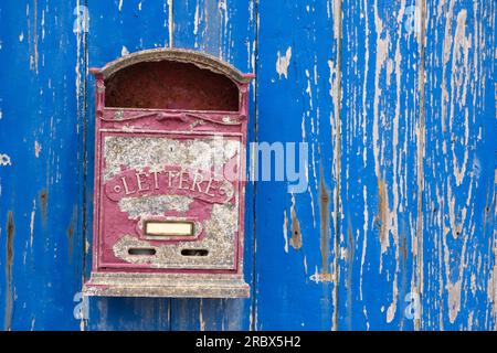 Alte rote Brieftasche an einer blauen Holzwand Stockfoto