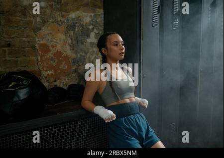 Sportliche junge Boxerin mit Müdigkeit und Energieverlust nach hartem Training Stockfoto