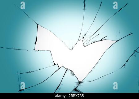 Ein Loch mit Rissen auf dem Glas. Zerbrochenes Fenster auf blauem Hintergrund Stockfoto