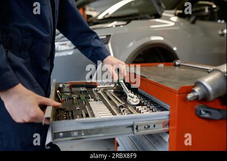 Nahaufnahme von Kfz-Technikern, die das Instrument aus dem Werkzeugkasten nehmen Stockfoto