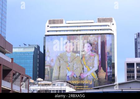 Riesenporträt von König Vajiralong korn und Königin Suthida von Thailand auf der Seite des C.P. Tower1, Bezirk Silom, Bangkok, Thailand. Thailands Ministerpräsident Prayuth Chan-ocha sagte am 11. Juli 2023, dass er sich aus der Politik zurückzieht, aber vorübergehend die Führung behalten wird. Dies geschieht, nachdem seine politische Partei, United Thai Nation, bei den Wahlen im Mai 14 einen großen Verlust erlitten hat. Die Move Forward Party, eine sozialdemokratische und fortschrittliche politische Partei, war der größte Wahlsieger. Am 13. Juli 2023 bereitet sich das neue Parlament darauf vor, eine Abstimmung darüber abzuhalten, wer der nächste Premierminister sein wird. Stockfoto