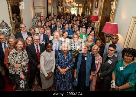 Queen Camilla posiert mit Gästen bei einem Empfang im Clarence House, London, um den 15. Jahrestag der Wohltätigkeitsorganisation „The First Story“ zu feiern. Bilddatum: Dienstag, 11. Juli 2023. Stockfoto