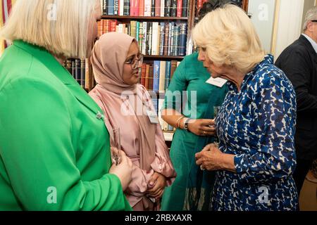 Königin Camilla spricht mit Habiba Desai, Mitbegründerin eines unabhängigen Verlagsunternehmens, während eines Empfangs im Clarence House, London, um den 15. Jahrestag der Wohltätigkeitsorganisation „The First Story“ zu feiern. Bilddatum: Dienstag, 11. Juli 2023. Stockfoto