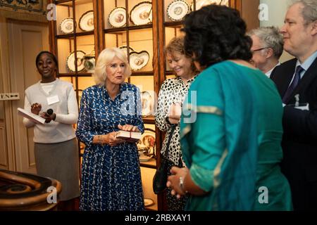 Queen Camilla wird während eines Empfangs im Clarence House, London, mit einer Sammlung von Büchern überreicht, um den 15. Jahrestag der First Story Wohltätigkeitsorganisation zu feiern. Bilddatum: Dienstag, 11. Juli 2023. Stockfoto