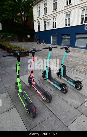 Auf dem Bürgersteig in Stavanger, Norwegen, geparkte elektrische Roller, die auf ihre nächsten Mieter warten. Stockfoto