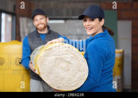 Zwei professionelle Baumeister umhüllen Wände mit Isolierung Stockfoto