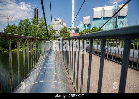 Stuttgart, Deutschland. 11. Juli 2023. Rohrleitungen führen vom EnBW-Kraftwerk in Stuttgart-Münster über eine Fußgängerbrücke weg. Kredit: Christoph Schmidt/dpa/Alamy Live News Stockfoto