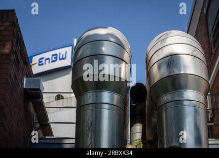 Stuttgart, Deutschland. 11. Juli 2023. Rohrleitungen sind am EnBW-Kraftwerk Stuttgart-Münster vor dem EnBW-Logo zu sehen. Kredit: Christoph Schmidt/dpa/Alamy Live News Stockfoto