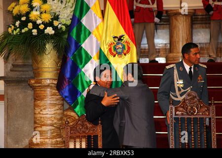 LA PAZ, BOLIVIEN, 19. Juni 2012. Der bolivianische Außenminister David Choquehuanca (links) begrüßt den iranischen Präsidenten Mahmoud Ahmadinedschad (Zentrum) nach einem Treffen mit dem bolivianischen Präsidenten Evo Morales Ayma im Präsidentenpalast in La Paz. Während des Treffens überarbeiteten die Präsidenten frühere bilaterale Abkommen und versprachen, die politischen und wirtschaftlichen Beziehungen weiter auszubauen und im Kampf gegen den Drogenhandel zusammenzuarbeiten. Der Iran unterstützt und finanziert bereits Industrie-, Gesundheits- und Sanitärprojekte in Bolivien. Stockfoto