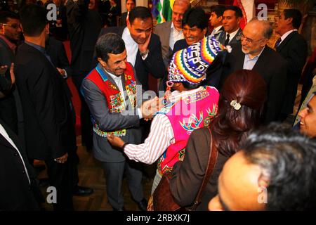 LA PAZ, BOLIVIEN, 19. Juni 2012. Nach seinem Treffen mit dem bolivianischen Präsidenten Evo Morales Ayma im Präsidentenpalast in La Paz begrüßt ein bolivianischer indigener Führer in traditioneller Kleidung den iranischen Präsidenten Mahmoud Ahmadinedschad. Während des Treffens überarbeiteten die Präsidenten frühere bilaterale Abkommen und versprachen, die politischen und wirtschaftlichen Beziehungen weiter auszubauen und im Kampf gegen den Drogenhandel zusammenzuarbeiten. Der Iran unterstützt und finanziert bereits Industrie-, Gesundheits- und Sanitärprojekte in Bolivien. Stockfoto