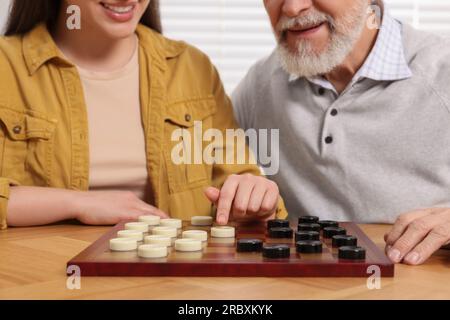 Dame spielen. Senior-Mann, lernende Frau am Tisch im Raum, Nahaufnahme Stockfoto