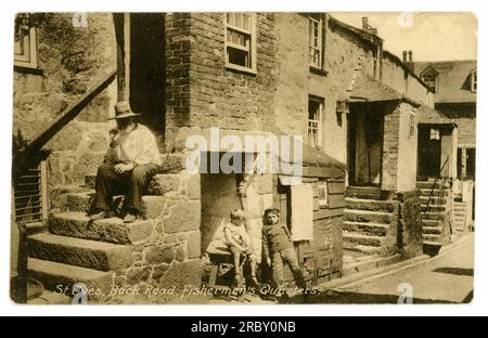 Originale Postkarte aus dem frühen 19. Jahrhundert, auf der Fischer eine Pfeife auf den Stufen zu einem traditionellen Haus aus kornischem Stein in den Fischervierteln, Back Road East, St. Ives rauchten. Die Figuren sind Mr. Ninnis, Sammy Phillips und Jack Richards. Stockfoto