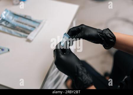 Nahaufnahme des unbekannten Zahnarztes im Schutzhandschuhöffnungspaket mit neuer Düse zum Polieren und Schleifen von Zähnen des Patienten Stockfoto