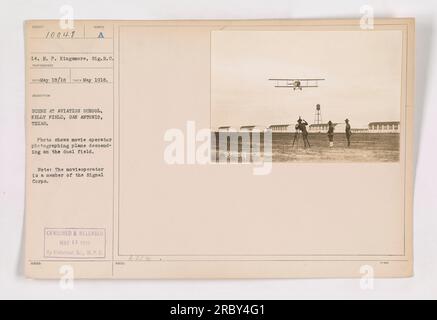 Flugzeugkadetten am Kelly Field in San Antonio, Texas, trainierten, während ein Filmemacher vom Signal Corps ihren Fortschritt dokumentierte. Das Foto erfasst den Moment, in dem das Flugzeug auf das Doppelfeld absteigt, während der Filmmitarbeiter die Szene aufnimmt. Das Bild wurde im Mai 1918 aufgenommen und von der Historischen Abteilung W.P.D. zensiert und veröffentlicht Stockfoto