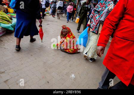 NAIROBI, KENIA, 04. JULI 2023: Ein Straßenbettler sitzt und wartet auf Hilfe von Passanten an den geschäftigen Straßen des Central Business District ( Stockfoto