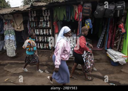 NAIROBI, KENIA - 04. JULI 2023: Die Bewohner gehen an den geschäftigen Händlern vorbei, die Waren an den Straßen der Slums von Kibera verkaufen. Diese Serie erfasst die täglichen l Stockfoto