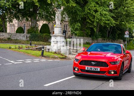 Ein Ford Mustang-Luxusfahrzeug, das durch das Dorf East Saltoun, East Lothian, Schottland, Großbritannien fährt Stockfoto