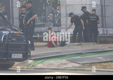 Madrid, Spanien. 11. Juli 2023. Ein Aktivist, der sich hingesetzt hat, wird von der spanischen Polizei bewacht, nachdem er vom Gerüst der Puerta de Alcala in Madrid abgesenkt wurde. Greenpeace-Aktivisten haben eine Leinwand an der Puerta de Alcala in Madrid aufgestellt, wo sie das mangelnde Interesse der 4 Kandidaten für die Präsidentschaft der spanischen Regierung bei den Wahlen am 23. Juli angeprangert haben.Sie sind über das Baugerüst geklettert, für das derzeit ein Gerüst installiert ist Restaurierung. Kredit: SOPA Images Limited/Alamy Live News Stockfoto