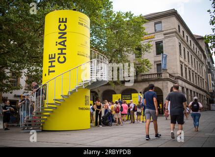 Stuttgart, Deutschland. 11. Juli 2023. Am Schlossplatz in Stuttgart passieren die Menschen einen kleinen Aussichtsturm, der Teil der Informations- und Werbekampagne „The Chänce“ ist. Kredit: Christoph Schmidt/dpa/Alamy Live News Stockfoto