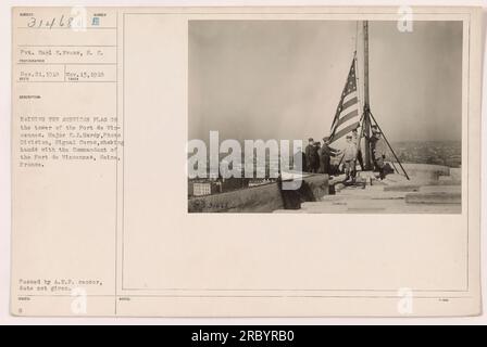 Soldaten hissen die amerikanische Flagge auf dem Turm von Fort de Vincennes, seine, Frankreich. Major E. J. Hardy von der Fotoabteilung, Signalkorps, sah, wie er dem Kommandanten des Forts die Hand schüttelte. Das Foto wurde am 13. November 1918 aufgenommen, am 21. Dezember 1918 erhalten und beschrieben. Er wurde vom A.E.P-Zensor übergeben, aber das Ausgabedatum wurde nicht angegeben. Stockfoto