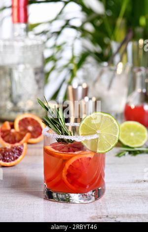 Roter sizilianischer Orange Paloma Cocktail mit Tequila, frischer Limette und Rosmarin mit rotem sizilianischem Orangensaft. Dieser Cocktail ist voller heller Zitrusaromen Stockfoto