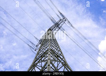 Hochspannungs-Stahlstab mit Stromleitungen diagonal von unten zum Himmel Stockfoto