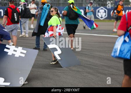 Fans ziehen während des FORMEL 1 ARAMCO BRITISH GRAND PRIX 2023 auf der Silverstone CI Werbespots ab und ziehen sie als Souvenir mit nach Hause Stockfoto