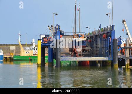 Den Oever, Niederlande. 9. Juli 2023. Den Oever Hafen mit den Fischerbooten und dem Leuchtturm. Hochwertiges Foto Stockfoto