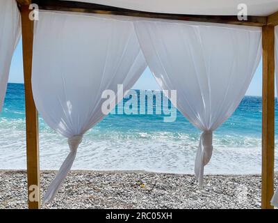 Weiße Strandüberdachungen. Luxuriöse Strandzelte in einem Resort. Strandkonzept Stockfoto