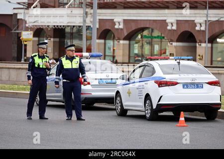 Zwei Verkehrspolizisten stehen neben ihrem Auto auf der Straße. Polizisten auf der Straße, Verkehrspolizist, Kriminalitätsbegriff, Verstoß gegen Verkehrsregeln Stockfoto