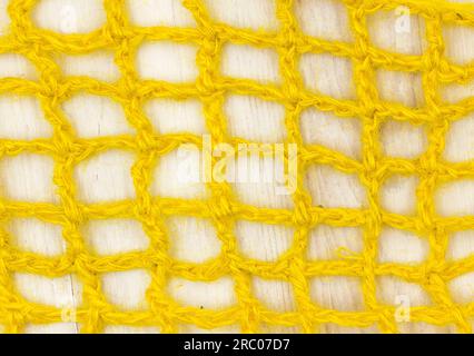 Strickmaterial aus gelber Jute, Mesh. Nahaufnahme. Hintergrund. Stockfoto