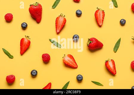 Frische Heidelbeeren und Erdbeeren auf gelbem Hintergrund Stockfoto