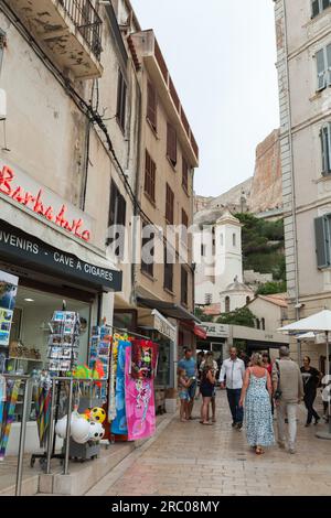 Bonifacio, Frankreich - 22. August 2018: An einem sonnigen Tag laufen die Menschen auf der Straße der kleinen Hafenstadt Korsika. Foto in vertikaler Straßenansicht Stockfoto