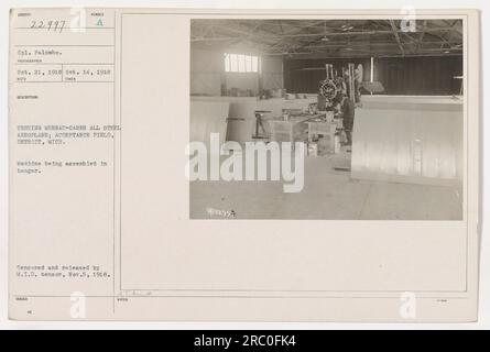 Bildunterschrift: 22997 Corporal Palumbo ist auf diesem Foto zu sehen während der Tests eines Murray-Carns All-Steel-Flugzeugs am 21. Oktober 1918 auf dem Abnahmefeld in Detroit, Michigan. Die Maschine wird in einem Hangar montiert. Das Bild wurde zensiert und vom Zensor der Military Information Division am 5. November 1918 veröffentlicht. Stockfoto