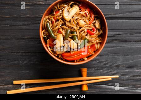 Teller mit Buchweizennudeln mit Gemüse, Pilzen, Hühnerfleisch, Draufsicht. Japanisches Soba in einer Tonschüssel Stockfoto