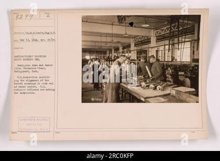 US Ordnance Officers überprüfen die Ausrichtung der Fassöffnungen an jedem Ende eines Wassermantels eines schweren Browning Maschinengewehrs im Remington Arms and Munitions Factories Plant in Bridgeport, Connecticut. Das Foto wurde am 13. Mai 1918 aufgenommen und zeigt den Herstellungsprozess während des Ersten Weltkriegs Stockfoto