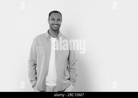 Porträt eines gutaussehenden jungen Mannes auf hellem Hintergrund, Platz für Text. Schwarzweiß-Effekt Stockfoto