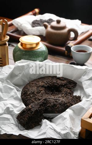 Gebrochener, scheibenförmiger pu-erh-Tee auf dem Tisch Stockfoto