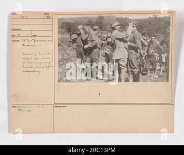 Titel: United States Marines in Frankreich, lernte während des Trainings Gasmaskeneinstellungen. Bildunterschrift: Im Januar 1918, USA Marines, die in Frankreich stationiert sind, haben eine wichtige Ausbildung absolviert, wie sie ihre Gasmasken richtig einstellen können. Dieses Bild zeigt einen französischen Armeeoffizier, der die Marines in einem Trainingslager unterweist. Stockfoto