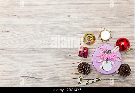 Weihnachtliche Geschenkboxen mit Blick aus dem hohen Winkel auf rustikalem Holzfußboden. Die Geschenke sind an den Rändern des Rahmens verstreut, sodass etwas Platz bleibt Stockfoto