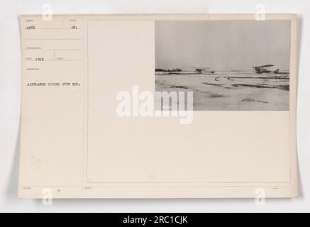 Flugzeuge, die im Ersten Weltkrieg über eisiges Gelände flogen. Foto von Wunder aus dem Jahr 1919, das militärische Aktivitäten darstellt. (Nummer des Fotos: 111-SC-2260) Stockfoto